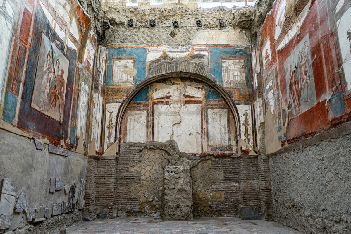 The frescoed College of the Augustales at Herculaneum (Ercolano), its blue and red Roman wall paintings and central apse preserved by the AD 79 eruption. UNESCO World Heritage since 1997.